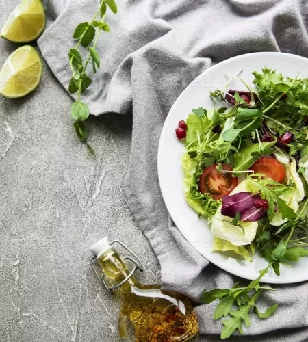 fresh-green-mixed-salad-bowl-with-tomatoes-and-microgreens-on-concrete-background-healthy-food-top-view-photo